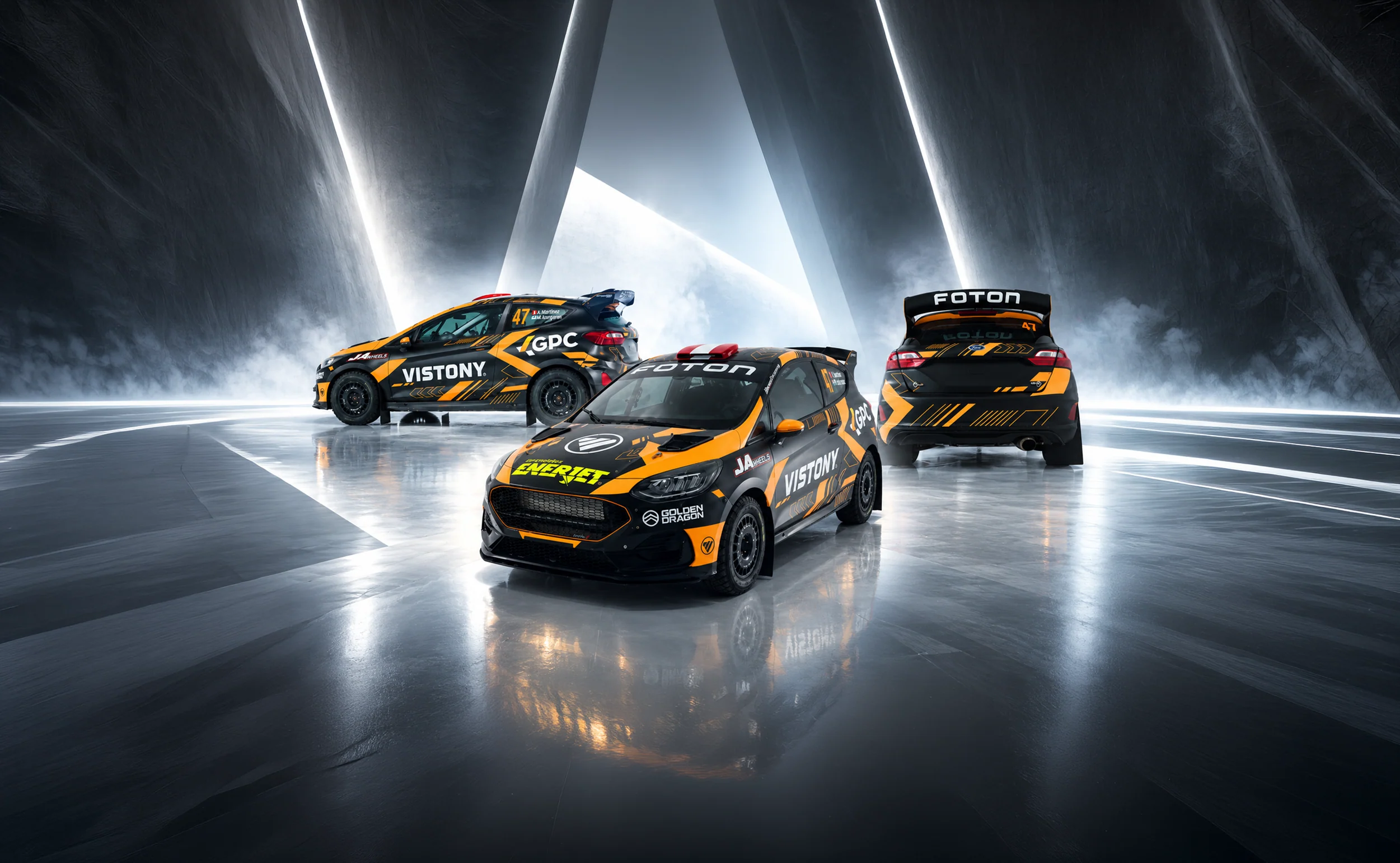 Tres autos del Racing Team Enerjet en una pista iluminada
